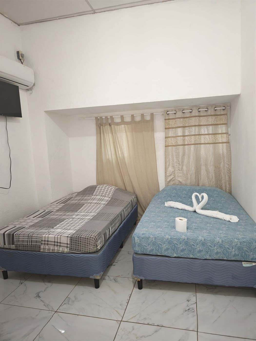 Habitación con dos camas, aire acondicionado y TV